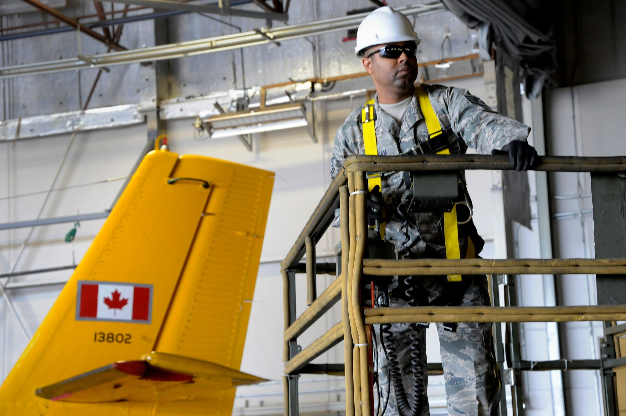 Oregon Air National Guard Staff Sgt. Brandon Bingham, assigned to the 142nd Fighter Wing Civil Engineer Squadron (CES) moves a scissor lift into place to install new lights for the 440th Squadron/Escadrille hangar, Yellowknife, Northwest Territories, Canada, July 21, 2017. The Oregon CES members are deployed for two-weeks for training along with CAF members from Cold Lake, Alberta. (U.S. Air National Guard photo/Master Sgt. John Hughel, 142nd Fighter Wing Public Affairs)