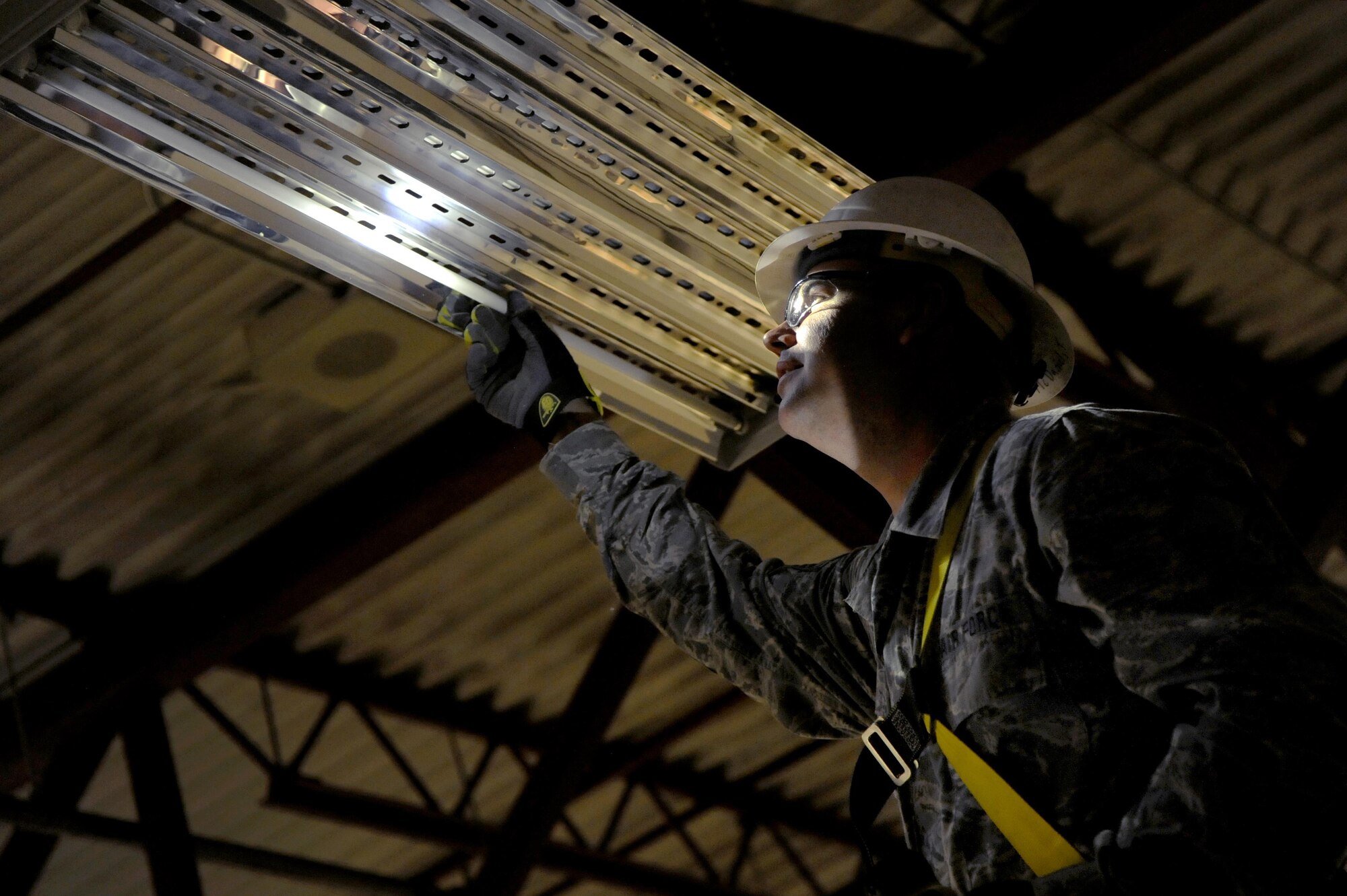 Oregon Air National Guard Master Sgt. Travis McDaniel, assigned to the 142nd Fighter Wing Civil Engineer Squadron (CES) inspects a hangar light fixture for replacement at the 440th Squadron/Escadrille, Yellowknife, Northwest Territories, Canada, July 21, 2017. Over 30 CES members are spending two-weeks in Canada working on a variety of projects during their Deployment for Training (DFT). (U.S. Air National Guard photo/Master Sgt. John Hughel, 142nd Fighter Wing Public Affairs)