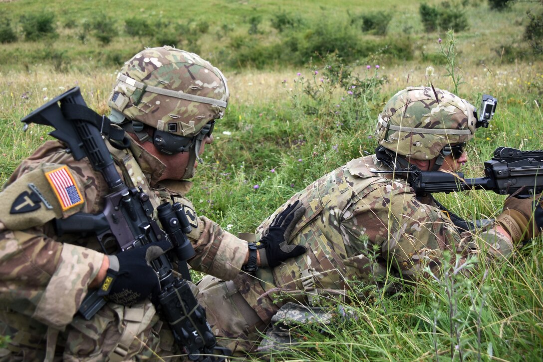 A soldier warns a team member to prepare to move.