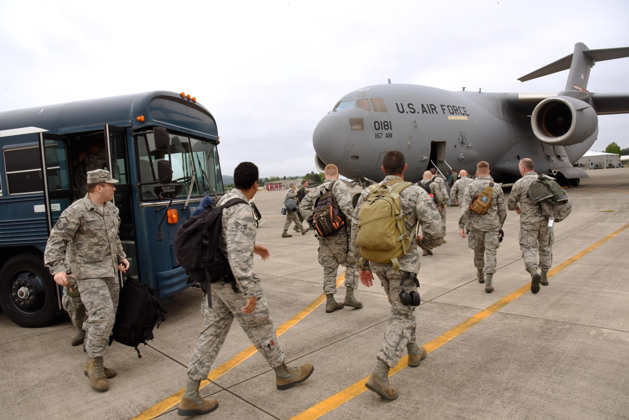Airmen from the 142nd Fighter Wing depart busses and begin to load a waiting C-17 Globemaster III at the Portland Air National Guard Base, Ore., that will transport them to Nellis Air Force Base, Nev., and support the Weapons Instructor Course, May 29, 2017 (U.S. Air National Guard photo by Master Sgt. John Hughel, 142nd Fighter Wing Public Affairs). 