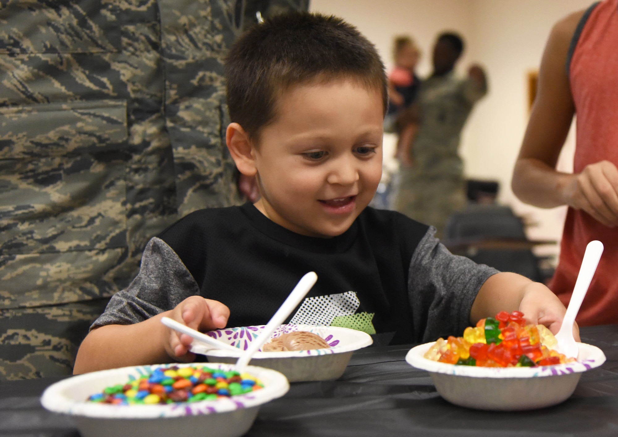 Everett Garcia, son of 2nd Lt. Anthony Garcia, 81st Security Forces Squadron operations officer, reaches for gummy bears during a family ice cream social at the 81st SFS building July 27, 2017, on Keesler Air Force Base, Miss. The event, hosted by the 81st SFS Defenders Council and Key Spouses, also consisted of a military working dog demonstration and a combat arms weapons display. (U.S. Air Force photo by Kemberly Groue)