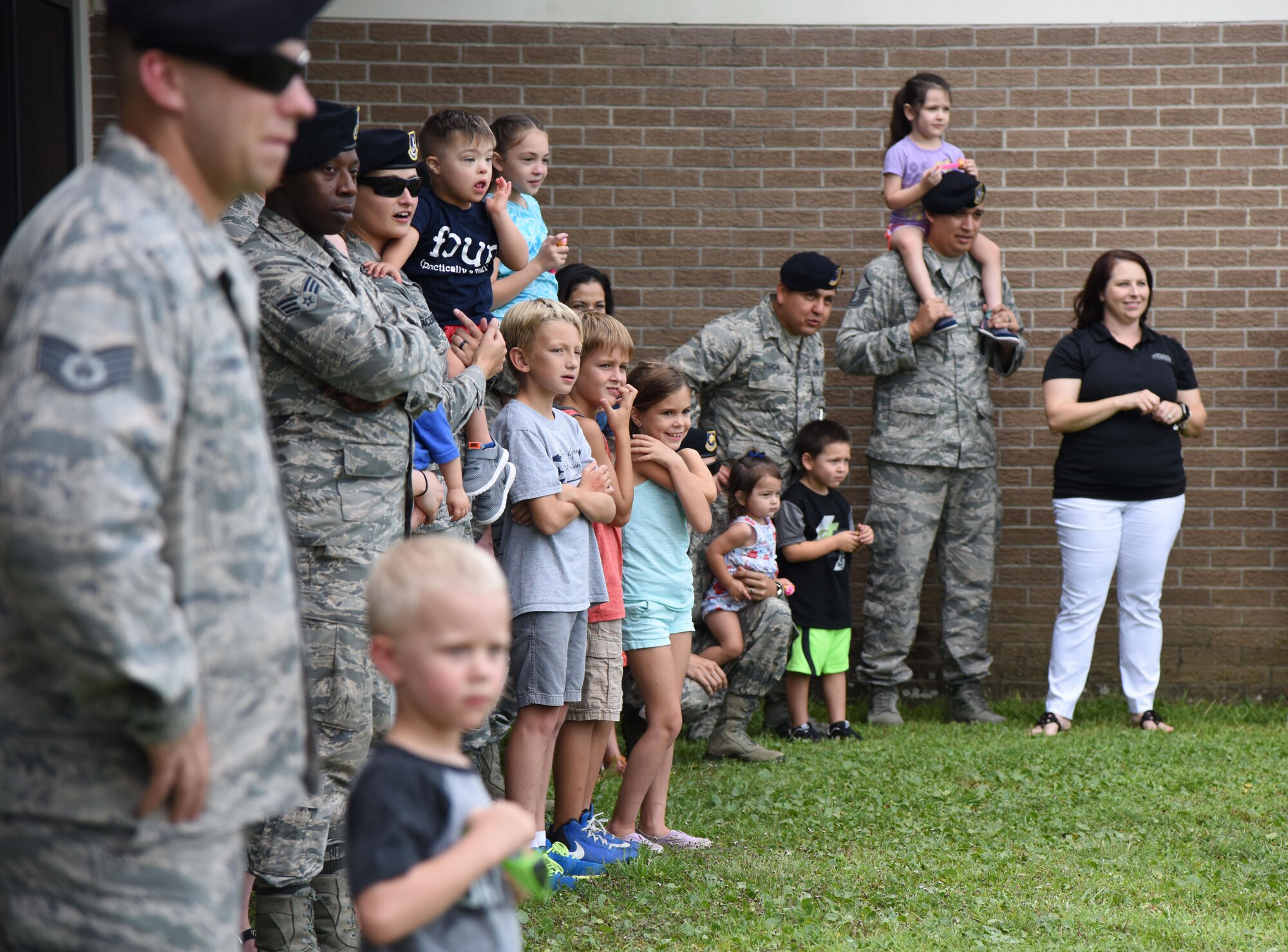 Member of the 81st Security Forces Squadron and their families attend a military working dog demonstration during a family ice cream social at the 81st SFS building July 27, 2017, on Keesler Air Force Base, Miss. The event, hosted by the 81st SFS Defenders Council and Key Spouses, also consisted of a combat arms weapons display and ice cream. (U.S. Air Force photo by Kemberly Groue)