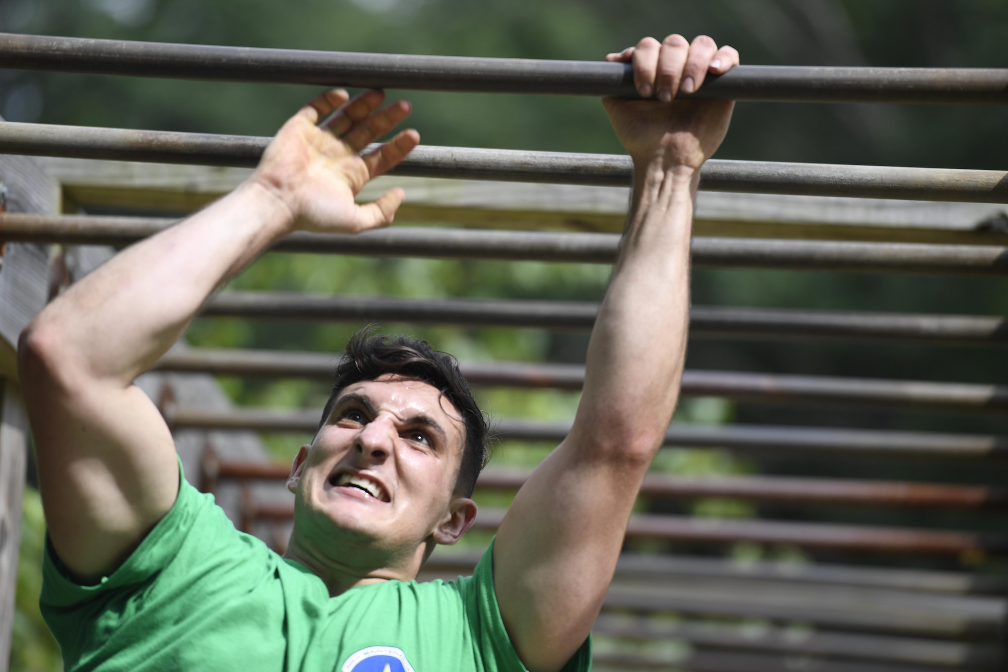 An airman with the 305th Air Mobility Wing swings through the monkey bars at the obstacle course on the Dix side of Joint Base McGuire-Dix-Lakehurst, New Jersey, July 28, 2017. The 305th AMW hosted a morale day, starting with a friendly competition at the obstacle course and ending with a combat dining-out on the McGuire side of the installation. 