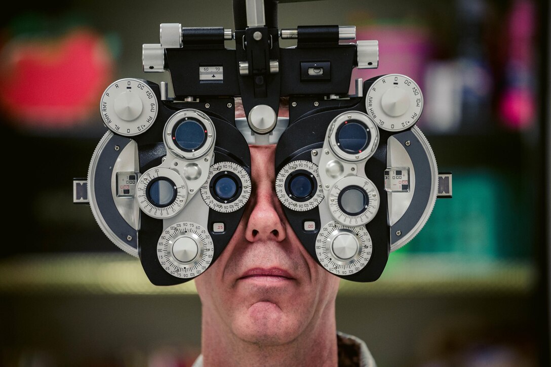 An optometrist helps set up a phoropter.