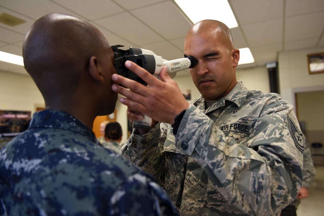 An optometry technician uses an auto refractor.