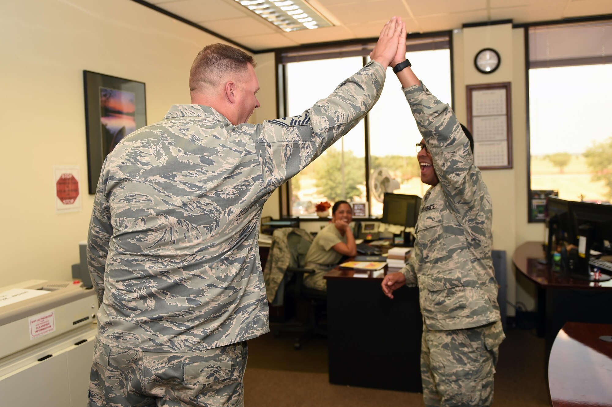 U.S. Air Force Senior Master Sgt. Zachary Merkl, 97th Force Support Squadron, 97th Communications Squadron, 97th Contracting Squadron and 97th Wing Staff Agency first sergeant, congratulates an airman’s on his accomplishments, July 24, 2017 at Altus Air Force Base, Oklahoma. First sergeants are the eyes and ears of the squadron for the commander to ensure Airmen are mission ready. (U.S. Air Force Photo by Airman 1st Class Cody Dowell/released)
