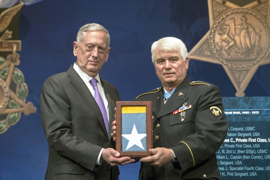 Defense Secretary Jim Mattis presents the Medal of Honor flag to Army Spc. 5 James C. McCloughan during McCloughan’s induction into the Pentagon’s Hall of Heroes, Aug. 1, 2017. McCloughan was awarded the Medal of Honor yesterday by President Donald J. Trump for distinguished actions as a combat medic during the Vietnam War. DoD photo by Air Force Tech. Sgt. Brigitte N. Brantley
