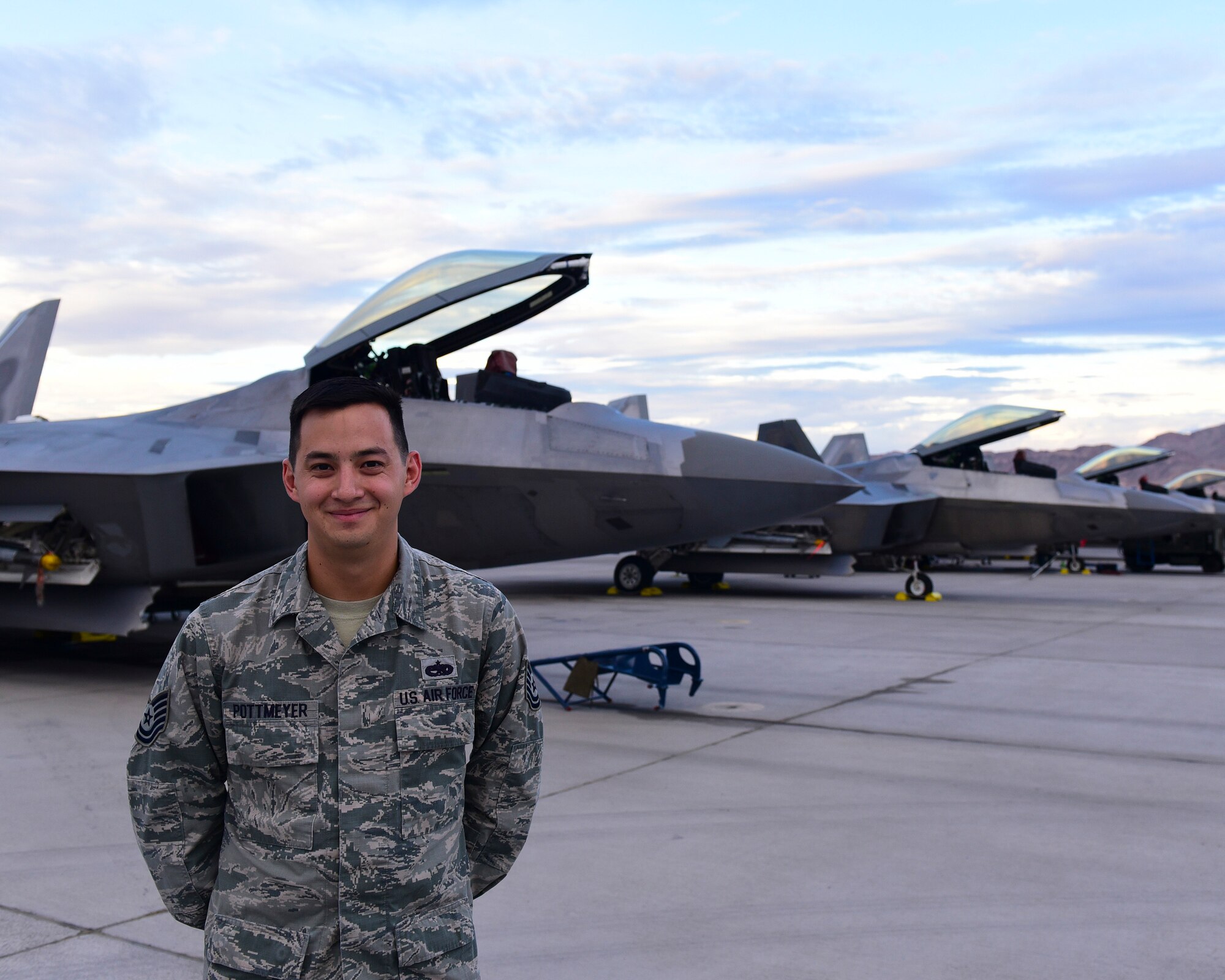 U.S. Air Force Tech. Sgt. Ryan Potmeyer, 325th Aircraft Maintenance Squadron crew chief, stands in front of 95th Fighter Squadron F-22s at Nellis Air Force Base, Nev., July 24, 2017. Potmeyer, and other maintenance professionals like him, came from Tyndall Air Force Base, Fla., to assist in exercise Red Flag 17-3. (U.S. Air Force photo by Senior Airman Cody R. Miller/Released)