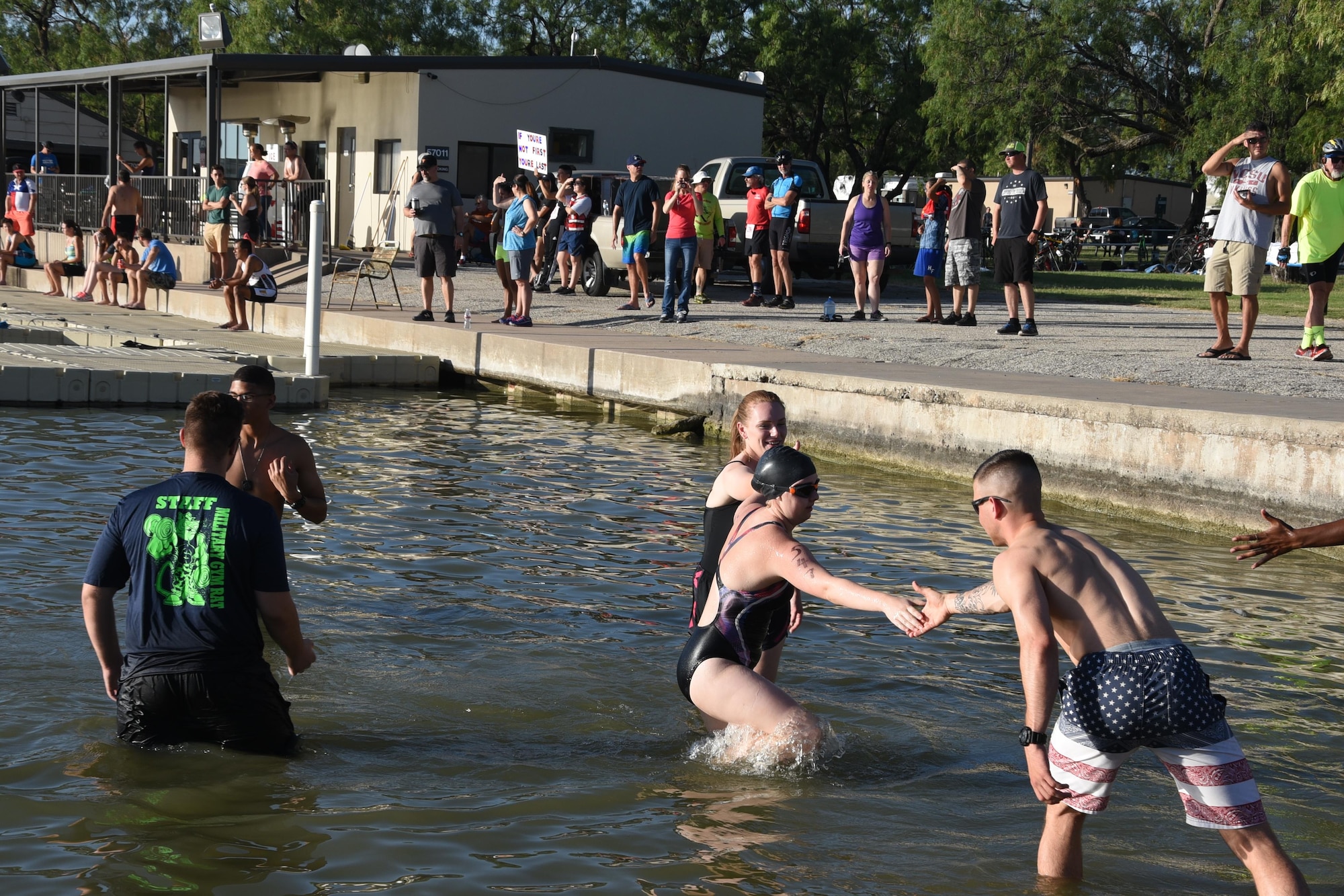 Volunteers from Goodfellow Air Force Base lend a hand at the 17th Force Support Squadron’s Annual Sprint Triathlon on July 29, 2017, at the Goodfellow recreational camp, in San Angelo, Texas. The swimmers received help getting up the boat ramp and out of Lake Nasworthy. (U.S. Air Force Photo by Amn Zachary Chapman/Released