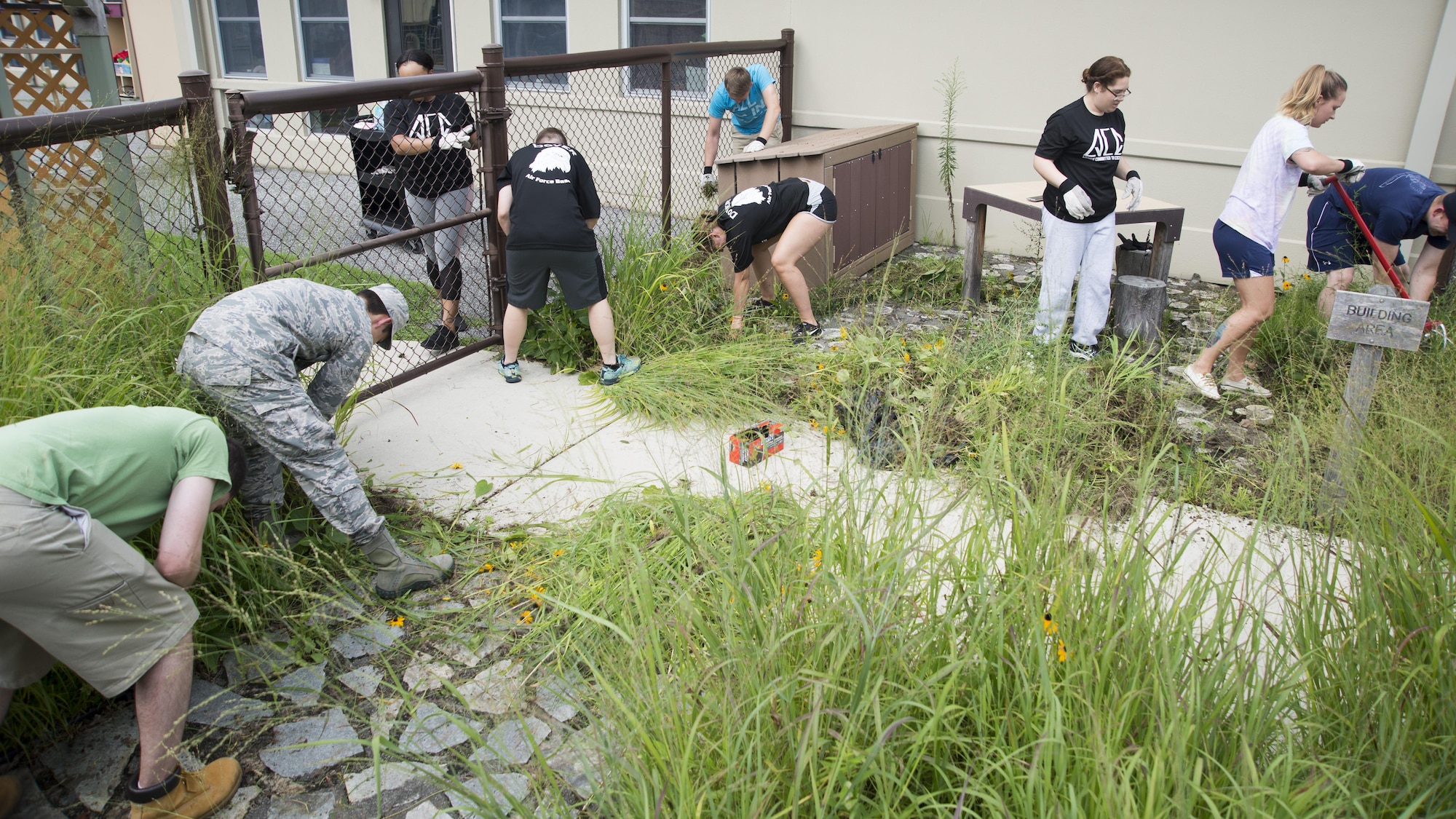 Airmen with the Airmen Committed to Excellence council clear out an area during a landscaping project July 27, 2017, at the Child Development Center on Dover Air Force Base, Del. The clean-up was to help the CDC prepare for an upcoming project for the children. (U.S. Air Force photo by Staff Sgt. Jared Duhon)