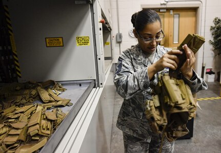 Master Sgt. Karen Harris, 1st Combat Camera Squadron Logistics Flight chief, inspects an ammunition carrier vest at Joint Base Charleston, South Carolina, July 25, 2017. The supply section of the flight is responsible for purchasing current Air Force-approved camera equipment and tactical gear to issue to members of the squadron.