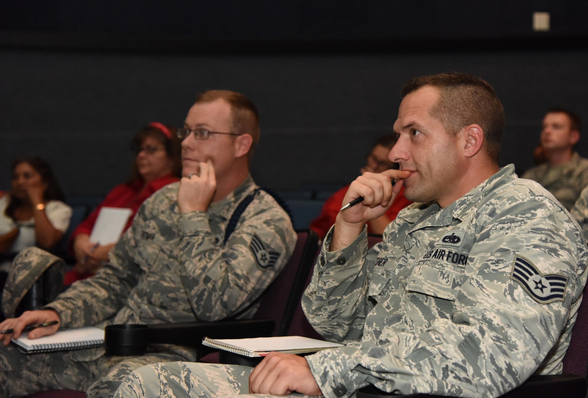 Staff Sgt. Travis Rayman, 335th Training Squadron military training leader, and Staff Sgt. Eric Dasher, 335th TRS instructor, attend the Base Operations Support town hall meeting at the Welch Theater July 26, 2017, on Keesler Air Force Base, Miss. The meeting was to discuss the new base operations support contract revisions. (U.S. Air force photo by Kemberly Groue)