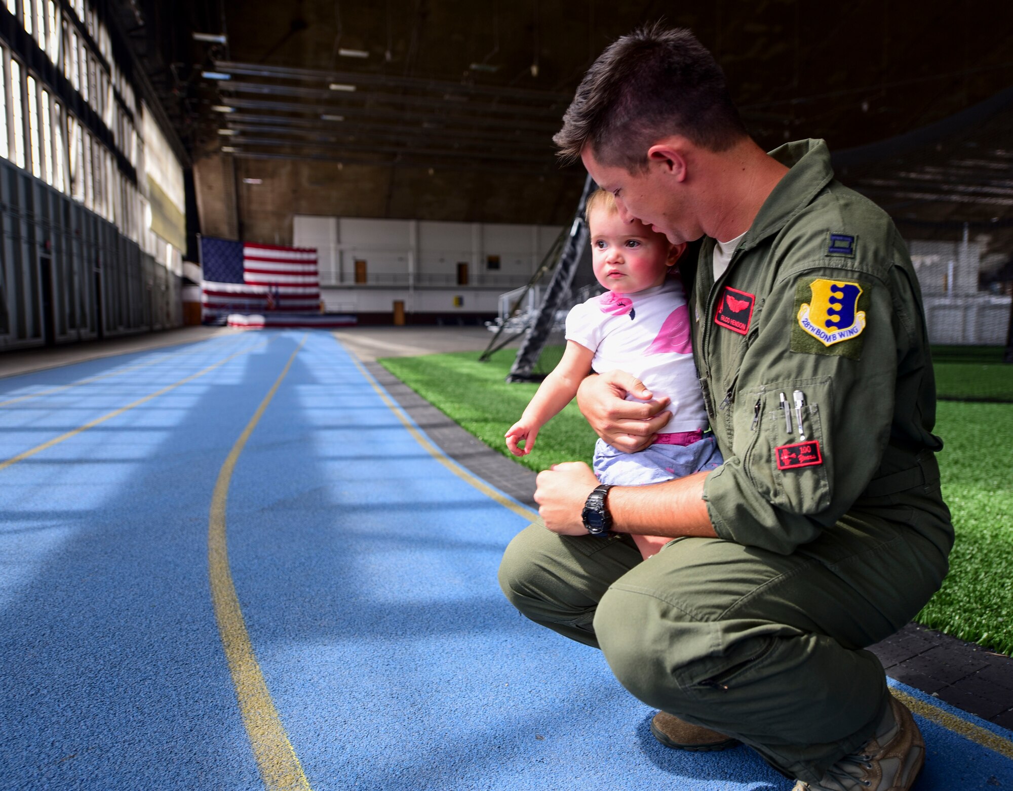 Capt. Jim Henson, a B-1 bomber pilot assigned to the 34th Bomb Squadron, holds his one year-old daughter, Charlotte, after returning from Red Flag 17-3. Red Flag is a joint-exercise that occurs at Nellis Air Force Base, Nevada, and includes air-to-air and air-to-ground scenarios to provide aircrews with a realistic combat environment. (U.S. Air Force photo by Airman 1st Class Randahl J. Jenson)