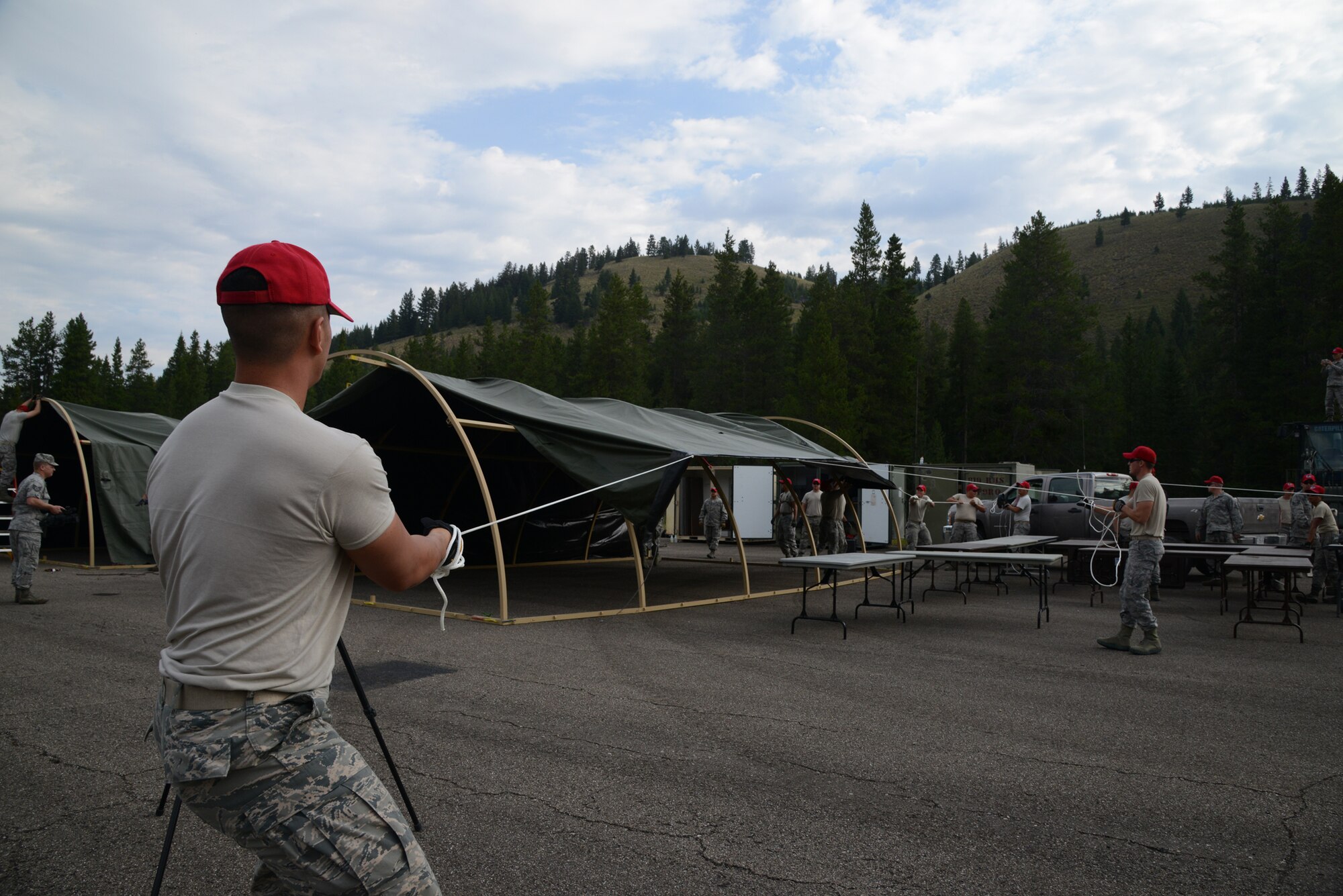 Airmen from the 819th RED HORSE Squadron pull tent fabric to cover an Alaskan small system shelter during an exercise July 27, 2017, at the Benchmark Airport near Augusta, Mont.