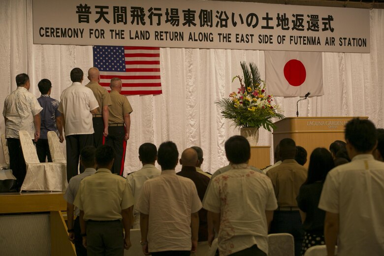 Local and military officials along with members of the Government of Japan stand