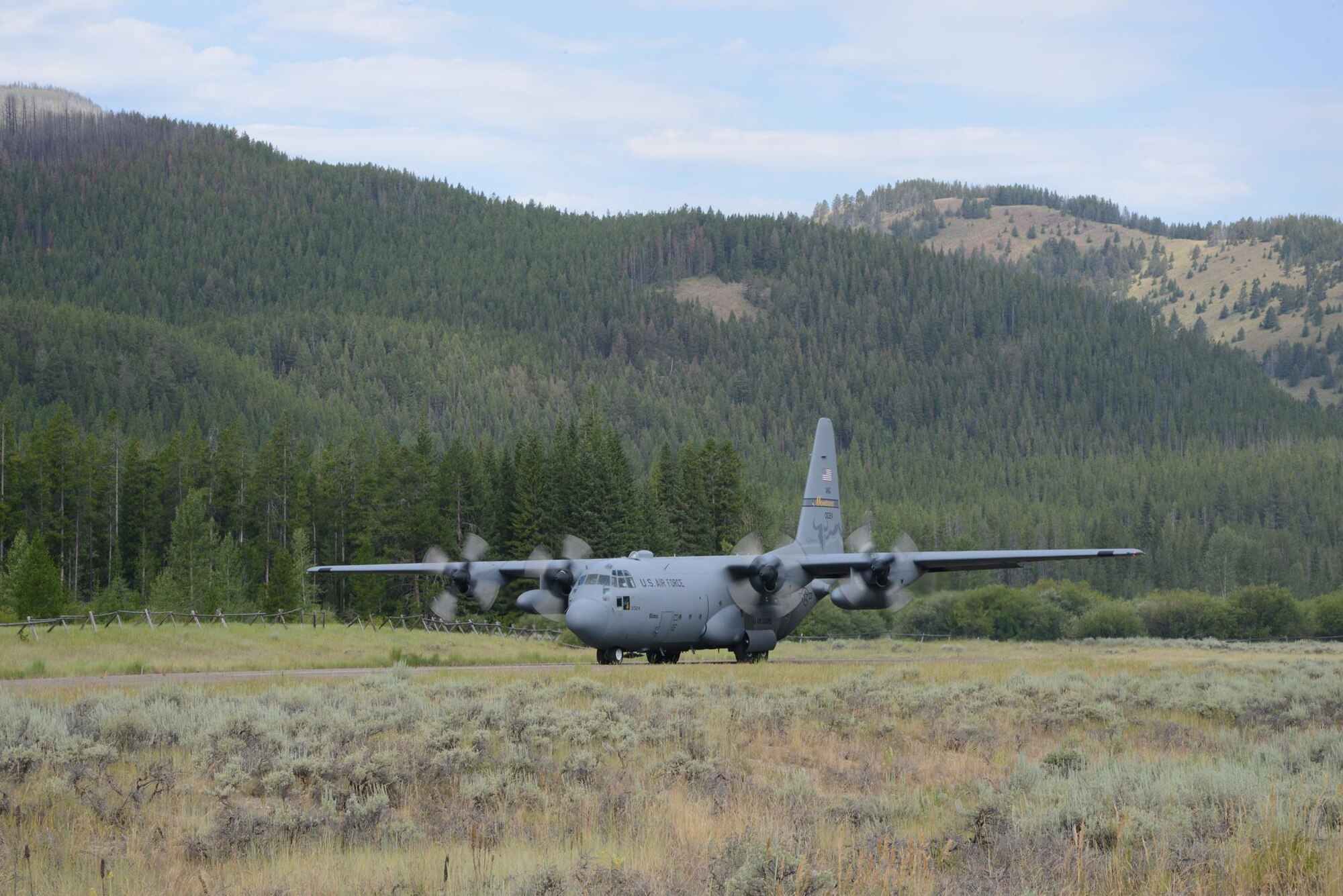 A C-130 Hercules aircraft from the 120th Airlift Wing, Montana Air National Guard backs up to the end of the air strip before taking off July 27, 2017, at the Benchmark Airport near Augusta, Mont.