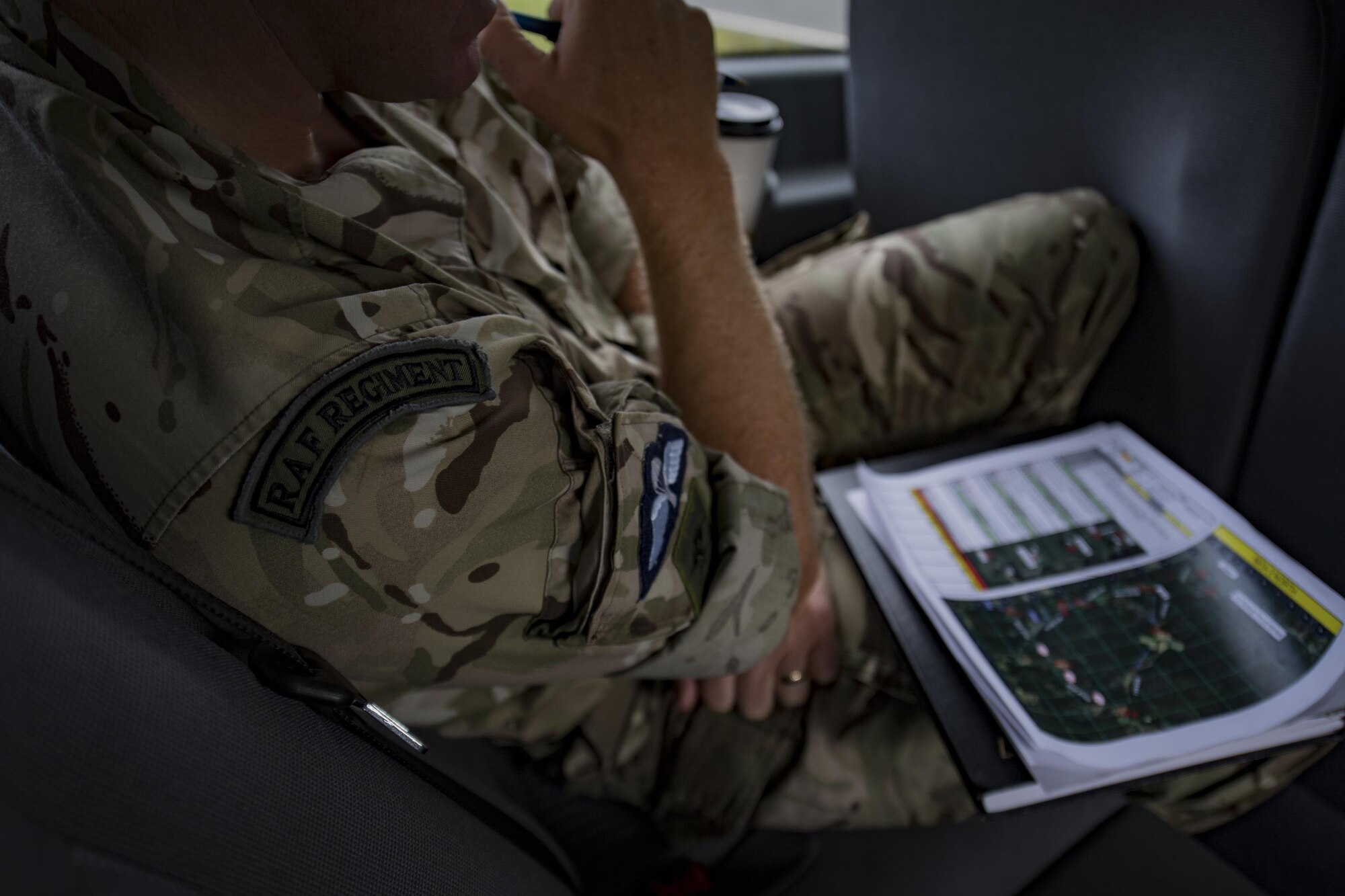 Royal Air Force Flight Sergeant Simon Ballard, chief instructor of the Air Land Integration Cell, listens in as joint terminal attack controllers communicate with 23d Fighter Group A-10C Thunderbolt IIs overhead during a close air support training exercise, July 26, 2017, in Lakeland, Ga. Two RAF members recently spent time with the 93d Air Ground Operations Wing to compare and contrast how each entity conducts business and to plan future coalition training events. (U.S. Air Force photo by Airman 1st Class Daniel Snider)