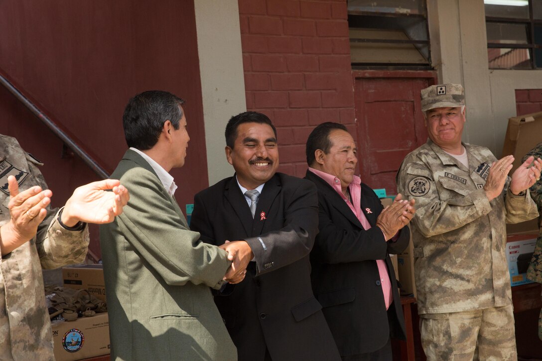 Miguel Sotelo, the mayor of Huarmey, Peru, and a city official shake hands after touring a school that received donations during a community relations event in Huarmey as part of UNITAS 2017, July 24, 2017. Much of Huarmey had been damaged by recent flooding, and Marines delivered more than 100 pallets of donated items from Project Handclasp for the city's hospital and schools. Project Handclasp is a U.S. Navy program that delivers humanitarian and educational materials donated by U.S. citizens. UNITAS is an annual, multinational exercise that focuses on strengthening existing regional partnerships and encourages establishing new relationships through the exchange of maritime mission-focused knowledge and expertise during multinational training operations. (U.S. Marine Corps photo by 1st Lt. Marco Valenzuela)
