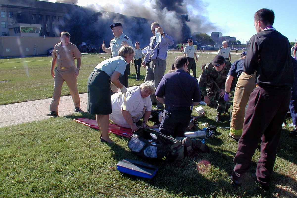 Medical personnel and volunteers work the first medical triage area outside the Pentagon after a hijacked commercial airliner crashed into the southwest corner of the building, Sept. 11, 2001. Navy photo by Petty Officer 1st Class Mark D. Faram
