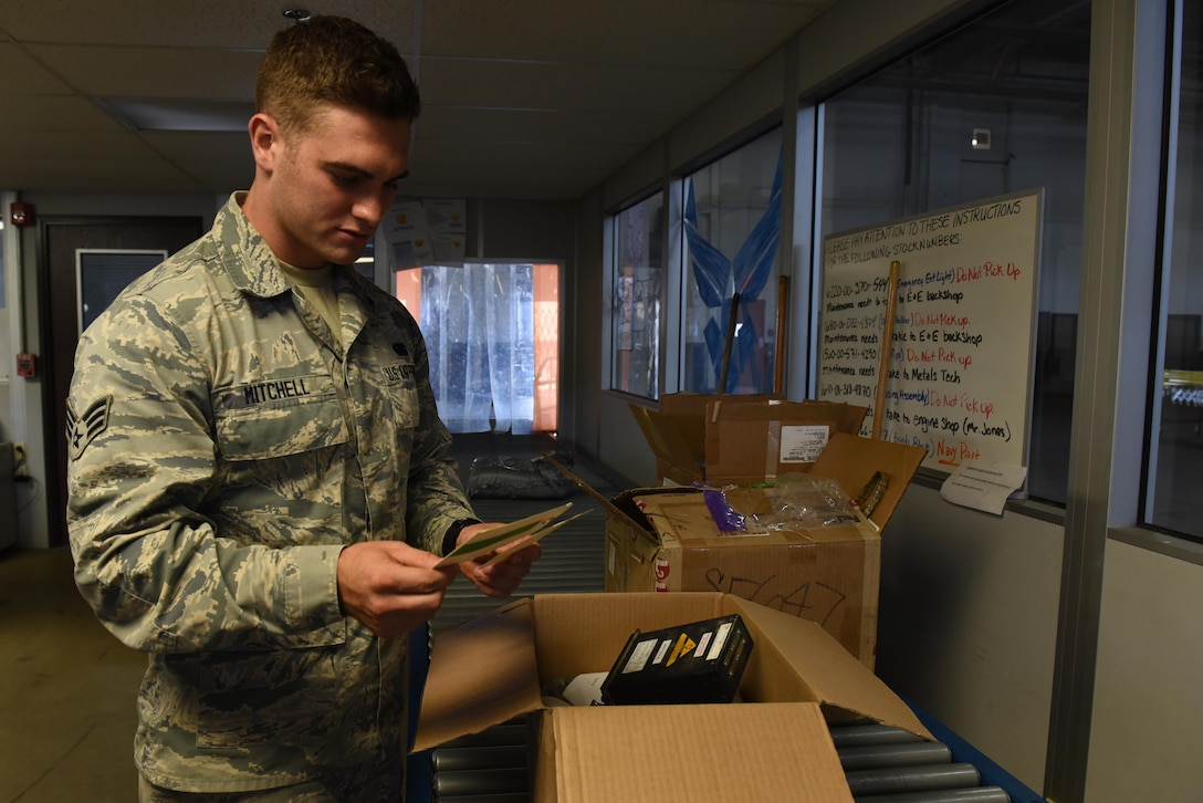 Male senior airman checks a returned item status that was on a industrial line.