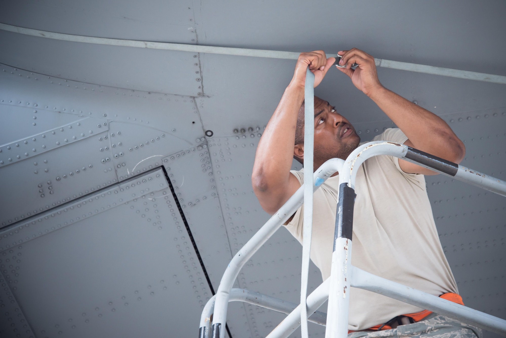 Senior Airman David Roby, 913th Maintenance Squadron crew chief from Little Rock Air Force Base, Arkansas, secures a tie down onto the wing of a C-130J Super Hercules aircraft July 21, 2017 at Keesler AFB, Mississippi. (U.S. Air Force photo/Staff Sgt. Heather Heiney)