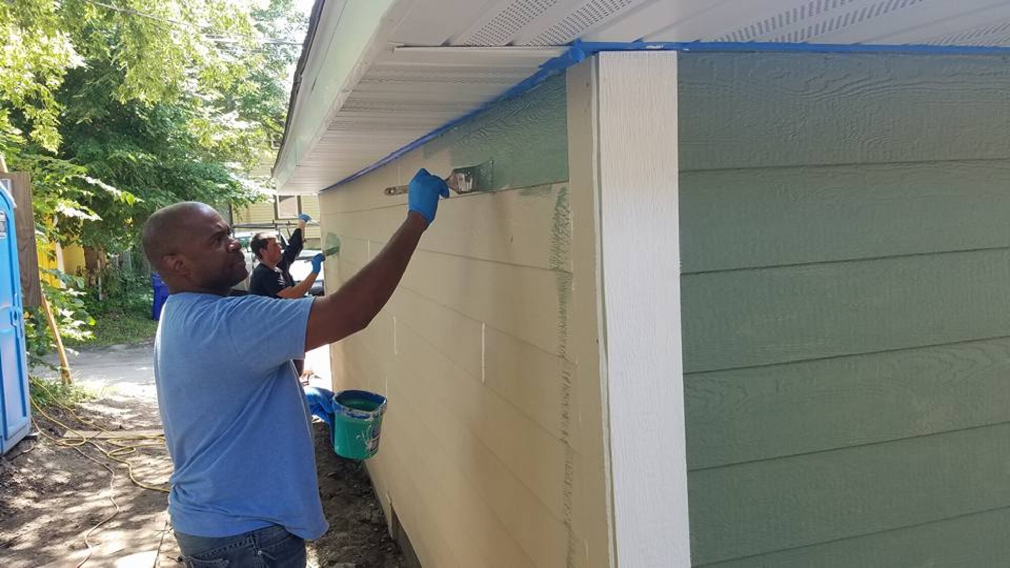 Tech. Sgt. Robert Lee, 934th Aircrew Flight Equipment, paints siding during a Habitat for Humanity project in St. Paul Aug. 28. (Courtesy Photo)