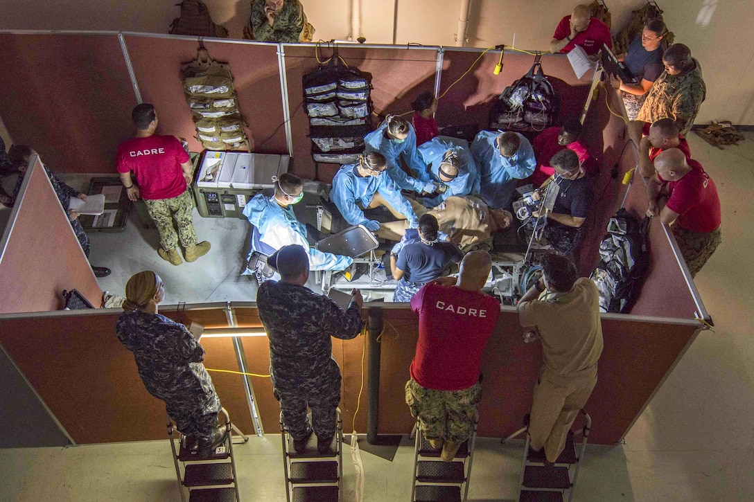 This image shows instructors watching medical staff conducting simulated surgical operations.