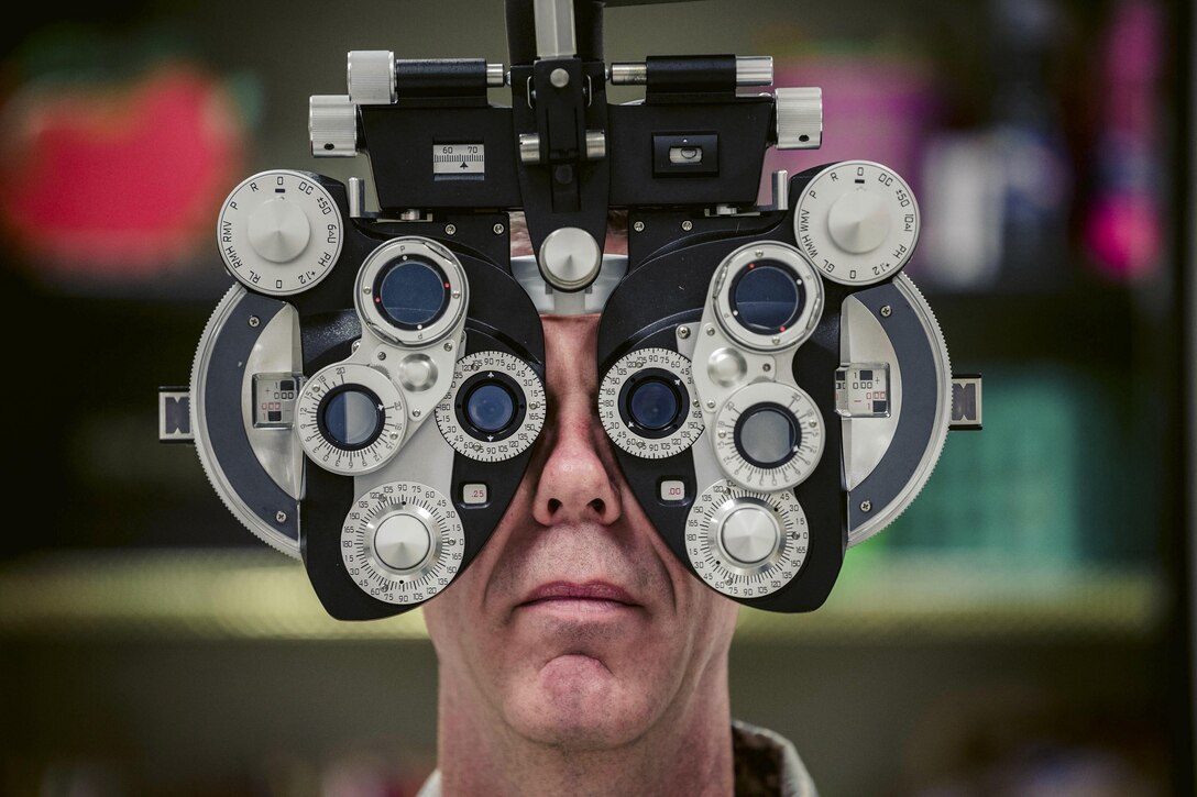 This image shows an airman looking through lenses.