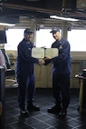 CAPT Tlapa congratulates BMCS Cichoracki as he is awarded the Coast Guard Commendation Medal.