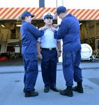 CS1 Densmore and CS3 Jackson present CS3 Taylor his new rank insignia, Petty Officer Third Class.