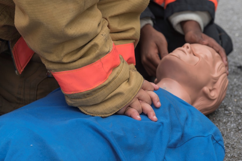 Fire Explorer Academy cadet performs CPR on a training dummy during an exercise.