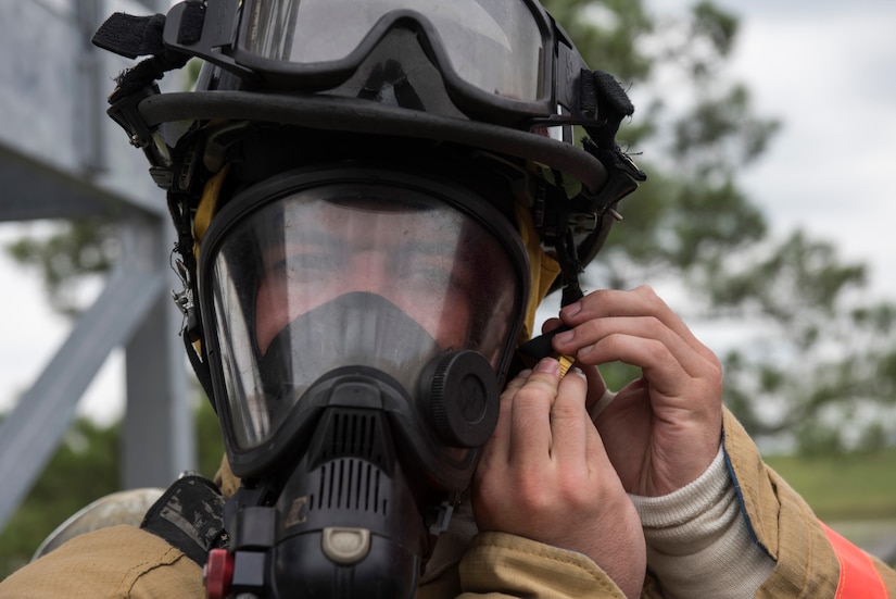 Fire Explorer Academy cadet Trevette Kuester dons his helmet during an exercise