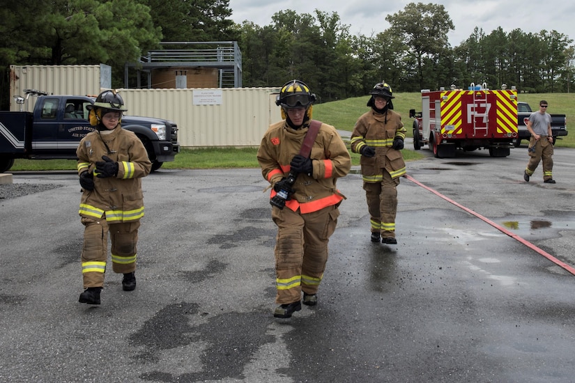 Fire Explorer Academy cadet performs a hose pull during a training exercise.