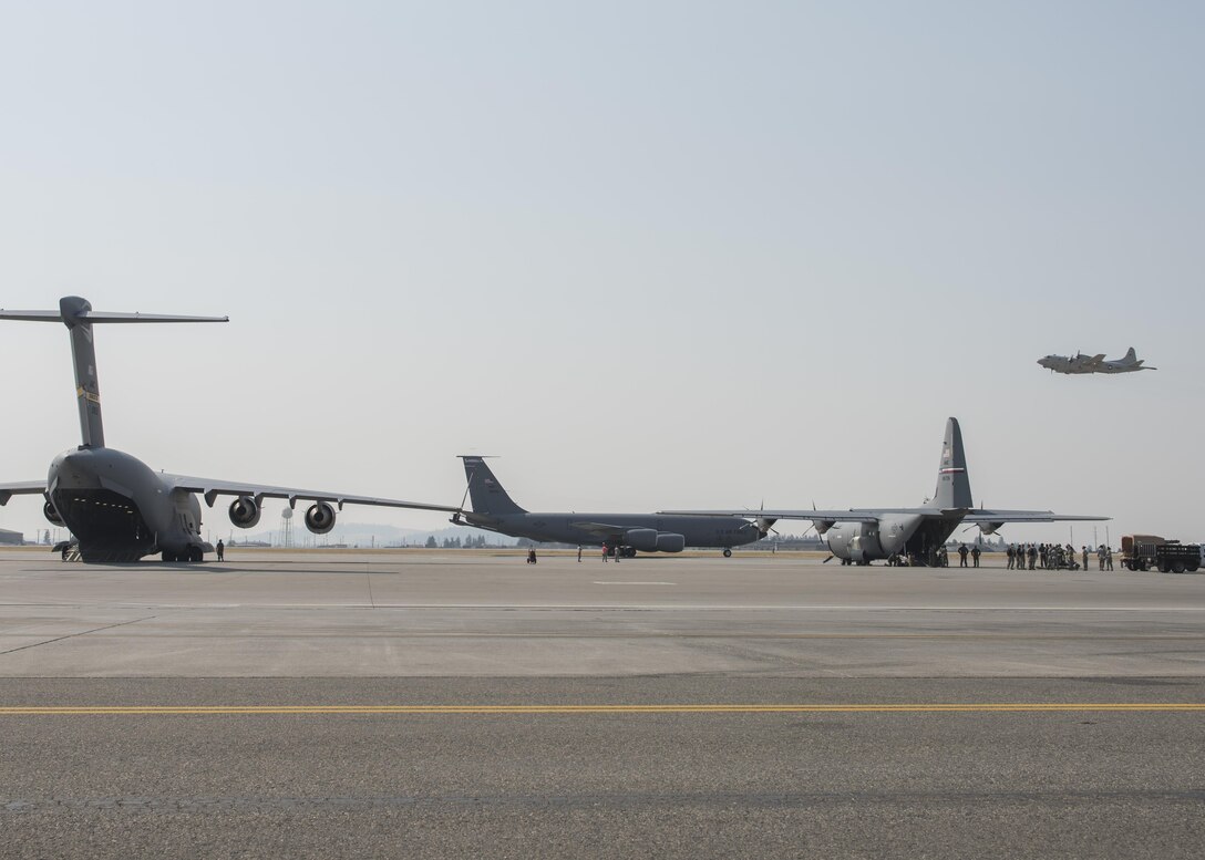 A P-3 Orion takes off while a C-17 Globemaster III, KC-135 Stratotanker and C-130 Hercules prepare for takeoff during the Mobility Guardian exercise Aug. 2, 2017, at Fairchild Air Force Base, Washington. Air Mobility Command's Mobility Guardian exercise is the largest the command has ever conducted and includes more than 60 aircraft from around the world. (U.S. Air Force photo / Airman 1st Class Ryan Lackey)