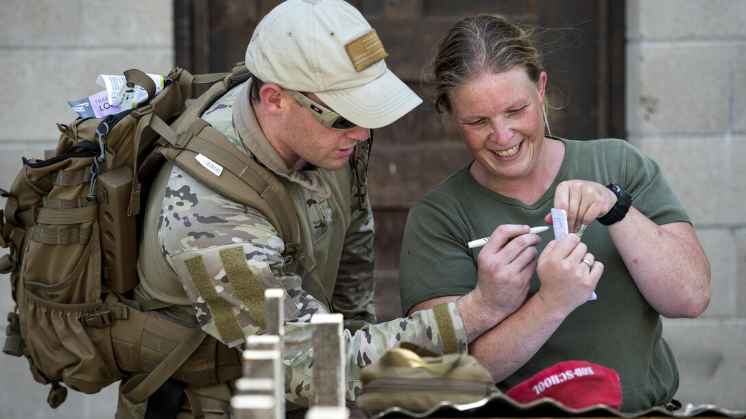 This image shows a U.S. airman looking at a map with a Belgian soldier.