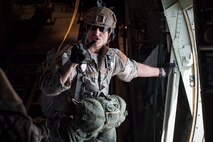 TSgt Sarrett gives a command prior to personnel jumping out of a C-130J Super Hercules