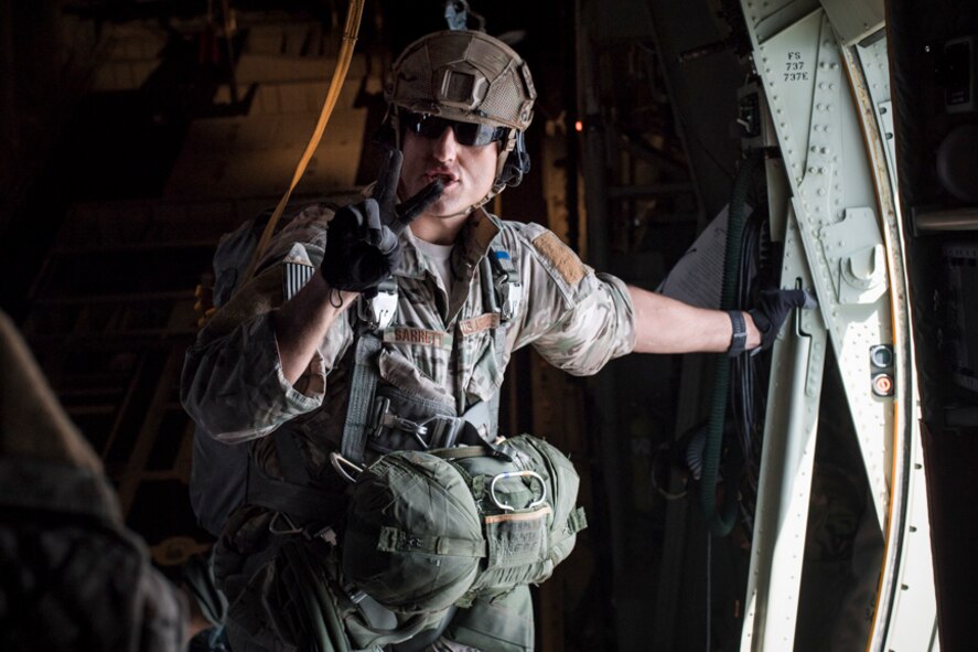 TSgt Sarrett gives a command prior to personnel jumping out of a C-130J Super Hercules