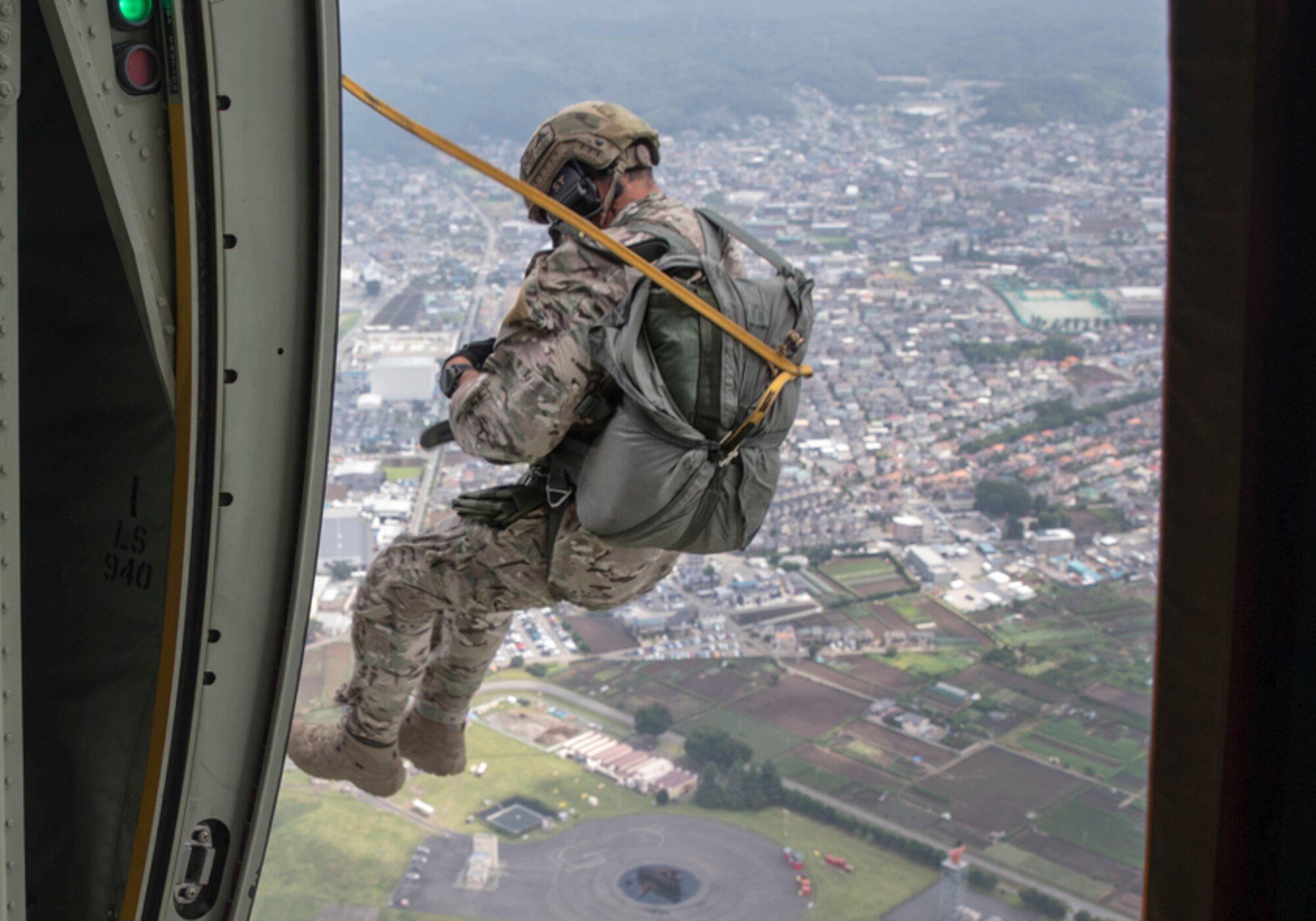 A SERE specialist jumps out of a C-130J Super Hercules
