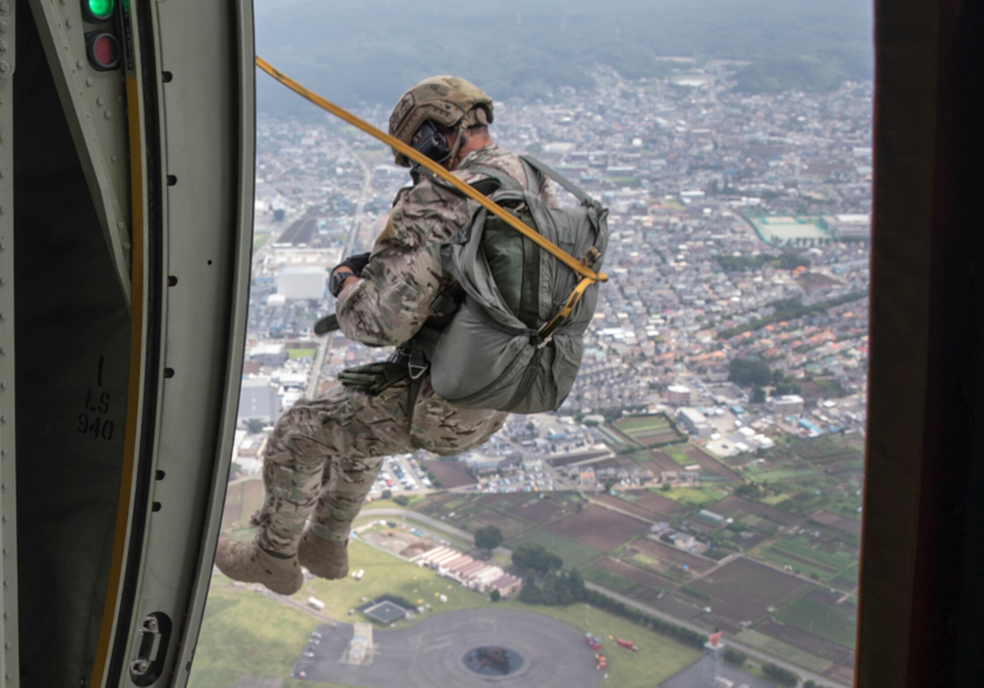 A SERE specialist jumps out of a C-130J Super Hercules