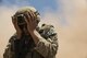 Airman 1st Class Jared Ball, EOD team member, shields his face from oncoming sand during fly-away training at the Florence Military Reservation in Florence, Ariz., July 21, 2017. The wind gusts caused from the Black Hawks take-off and landing kick up sand from the desert floor causing low visibility. (U.S. Air Force photo/Airman 1st Class Alexander Cook)