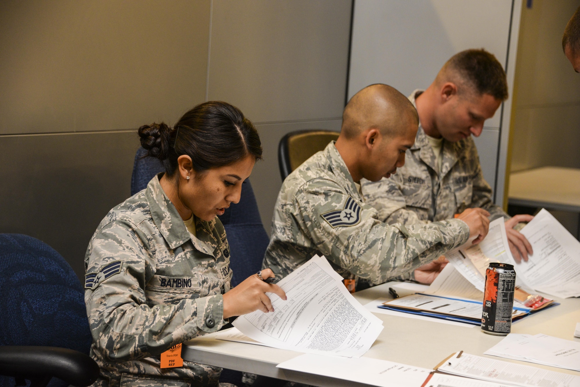 Senior Airman Samantha Bambino, 60th Force Support Squadron outbound assignments and career development technician and PDF representative, checks eligibility paperwork for Airmen from the 621st Contingency Response Wing at Travis Air Force Base, Calif., during a personnel deployment function line July 31, 2017. Teams from the 60th Air Mobility Wing and 621st CRW combined their efforts to support the deployment of more than 130 621st CRW Airmen in support of Exercise Mobility Guardian. (U.S. Air Force photo / 2nd Lt. Sarah Johnson)
