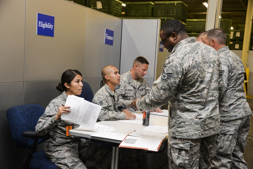 Senior Airman Samantha Bambino, 60th Force Support Squadron outbound assignments and career development technician and PDF representative, checks eligibility paperwork for Airmen from the 621st Contingency Response Wing at Travis Air Force Base, Calif., during a personnel deployment function line July 31, 2017. Teams from the 60th Air Mobility Wing and 621st CRW combined their efforts to support the deployment of more than 130 621st CRW Airmen in support of Exercise Mobility Guardian. (U.S. Air Force photo / 2nd Lt. Sarah Johnson)