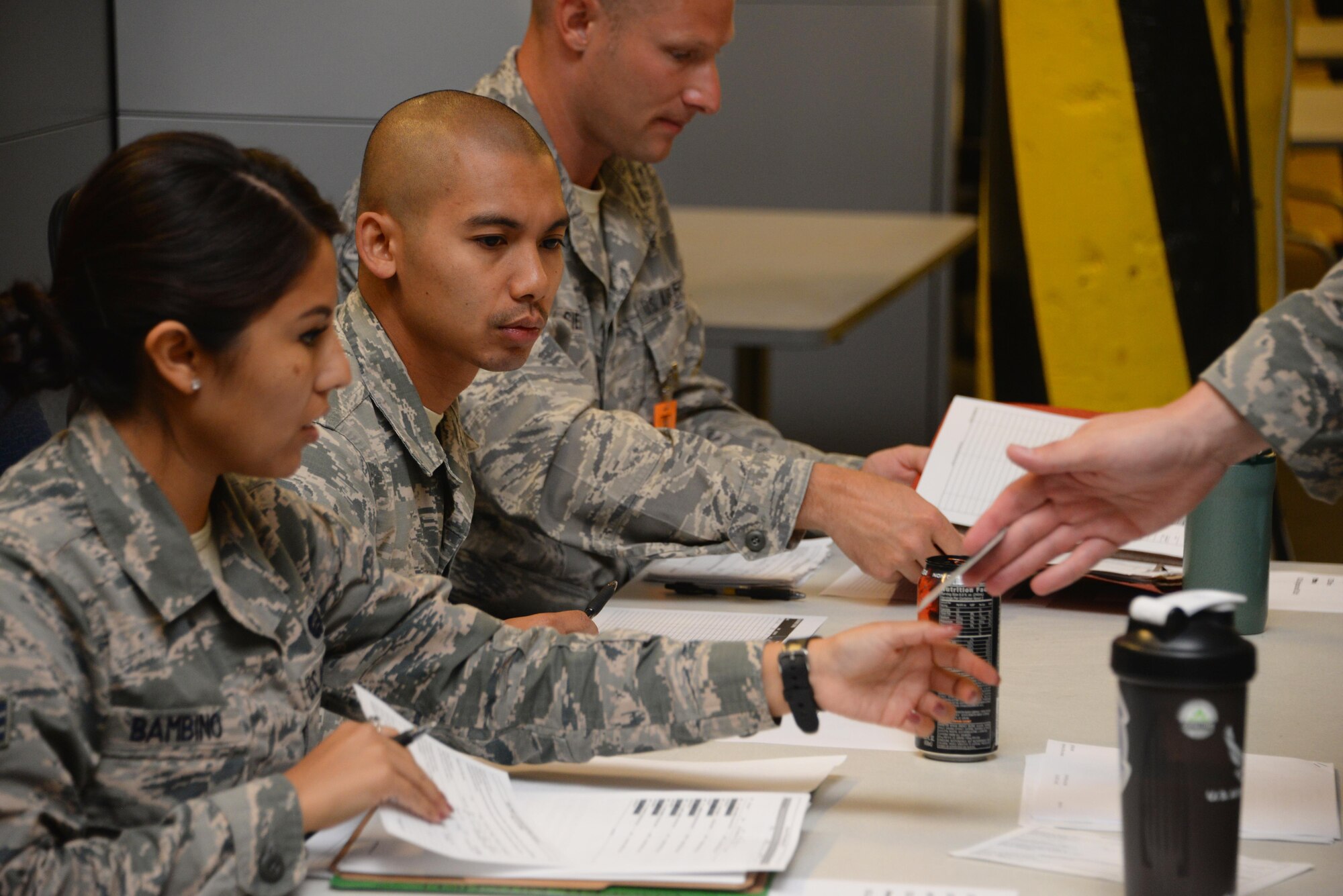 Senior Airman Samantha Bambino, 60th Force Support Squadron outbound assignments and career development technician and PDF representative, checks eligibility paperwork for Airmen from the 621st Contingency Response Wing at Travis Air Force Base, Calif., during a personnel deployment function line July 31, 2017. Teams from the 60th Air Mobility Wing and 621st CRW combined their efforts to support the deployment of more than 130 621st CRW Airmen in support of Exercise Mobility Guardian. (U.S. Air Force photo / 2nd Lt. Jessica Ward)