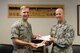 U.S. Air Force Capt. Nick Gumley, the 354th Medical Support Squadron TRICARE operations patient administration flight commander, hands Chief Master Sgt. Brent Sheehan, the 354th Fighter Wing command chief, his Air Force Ball tickets Aug. 2, 2017, at Eielson Air Force Base, Alaska. The Air Force is celebrating its 70th Birthday and Mineau and Sheehan were one of the first to purchase their tickets. (U.S. Air Force photo by Senior Airman Cassie Whitman)