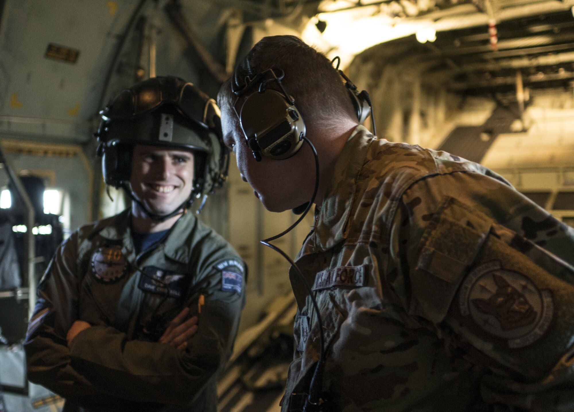 U.S. Air Force 17th Special Operations Squadron and No. 40 Squadron Royal New Zealand Air Force loadmasters discuss dissimilar formation tactics, training and procedures during a formation flight July 12, 2017, over Queensland, Australia. The bilateral training event represented the first time a 17th SOS MC-130J and 40 SQN C-130H(NZ) flew a dissimilar formation flight together. (U.S. Air Force photo by Capt. Jessica Tait)