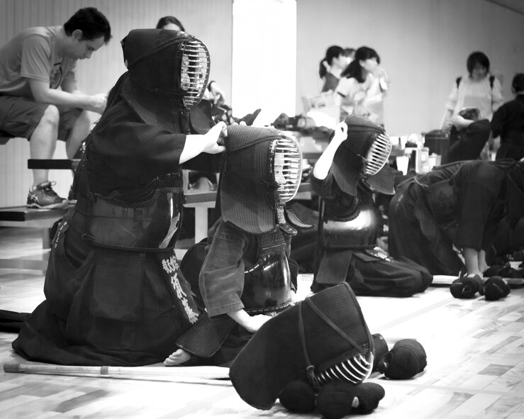 A kendo practitioner places headgear on a teammate during the Kendo Club Joint Summer Camp at Yokota Air Base, Japan, July 29, 2017.