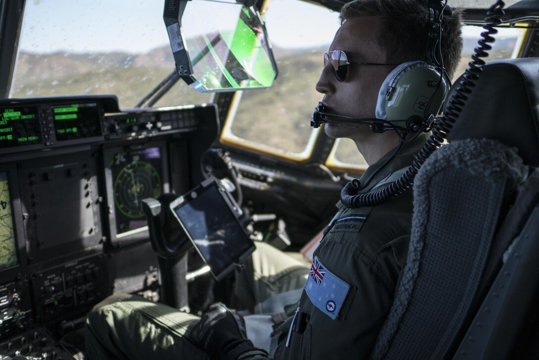 A No. 37 Squadron Royal Australian Air Force pilot looks out the window of a RAAF C-130J Hercules during a dissimilar formation flight with a U.S. Air Force 17th Special Operations Squadron MC-130J Commando II July 12, 2017 over Queensland, Australia. Talisman Saber 2017 provided the opportunity at further developing interoperability with counterparts from the RAAF through daily airborne operations to include low-level formation work, forward air refueling point, and personnel and cargo airdrops. (U.S. Air Force photo by Capt. Jessica Tait)