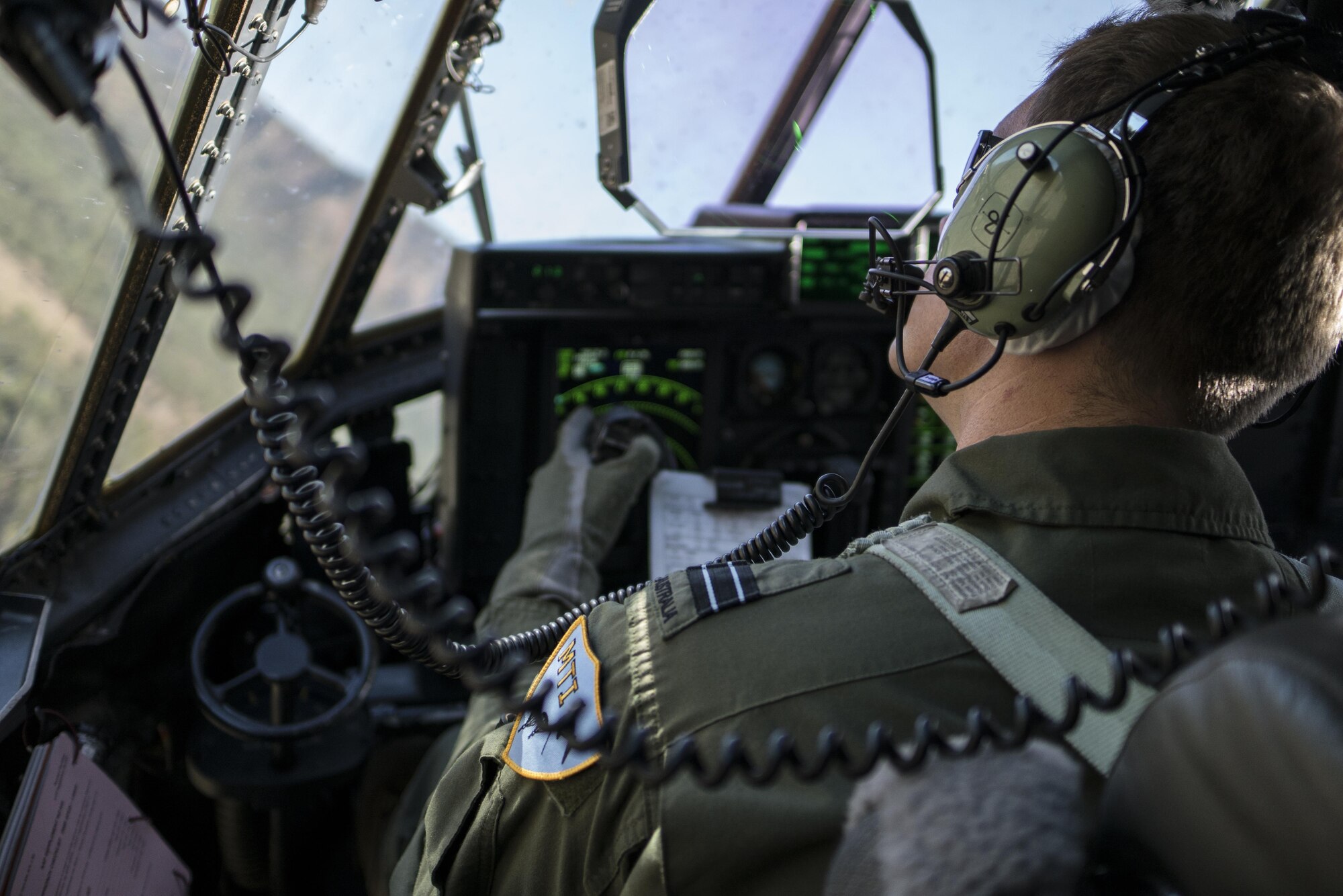 A No. 37 Squadron Royal Australian Air Force pilot looks out the window of a RAAF C-130J Hercules during a dissimilar formation flight with a U.S. Air Force 17th Special Operations Squadron MC-130J Commando II July 12, 2017 over Queensland, Australia. Talisman Saber 2017 provided the opportunity at further developing interoperability with counterparts from the RAAF through daily airborne operations to include low-level formation work, forward air refueling point, and personnel and cargo airdrops. (U.S. Air Force photo by Capt. Jessica Tait)