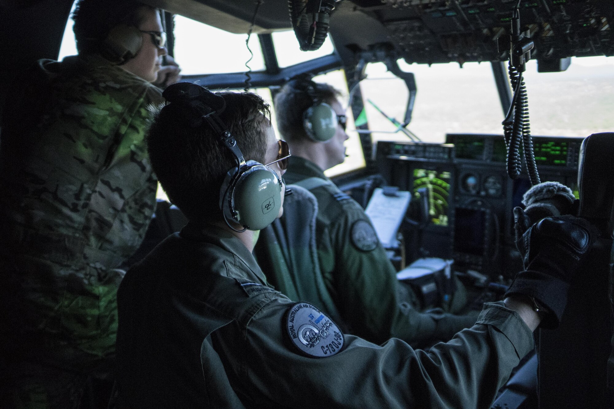 A U.S. Air Force 17th Special Operations Squadron combat systems operator flies as an observer on a No. 37 Squadron Royal Australian Air Force C-130J Hercules during a dissimilar formation flight with a U.S. Air Force MC-130J Commando II July 12, 2017, over Queensland, Australia. The development of dissimilar formation tactics, training and procedures enables greater interoperability between the U.S. and Australian militaries. (U.S. Air Force photo by Capt. Jessica Tait)