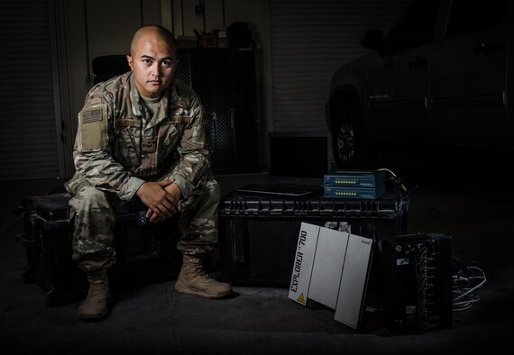 U.S. Air Force Staff Sgt. Junbryan Samson, a cyber network technician assigned to the U.S. Air Forces Central Command communications division at the Combined Air Operations Center sits next to a communications fly-away kit July 31, 2017, at Al Udeid Air Base, Qatar. Samson’s maintains and administers the CFK, which allows Airmen to establish crucial internet and voice links with bare-base resources anywhere in the world via wireless routers, very small aperture terminal satellite and broadband global area network satellite link (U.S. Air Force photo by Staff Sgt. Alexander W. Riedel)